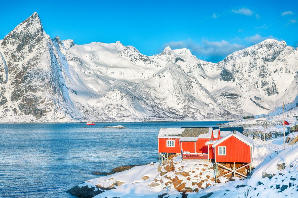 Traditional Norwegian red wooden houses on the shore of Reinefjorden in Hamnoy villa