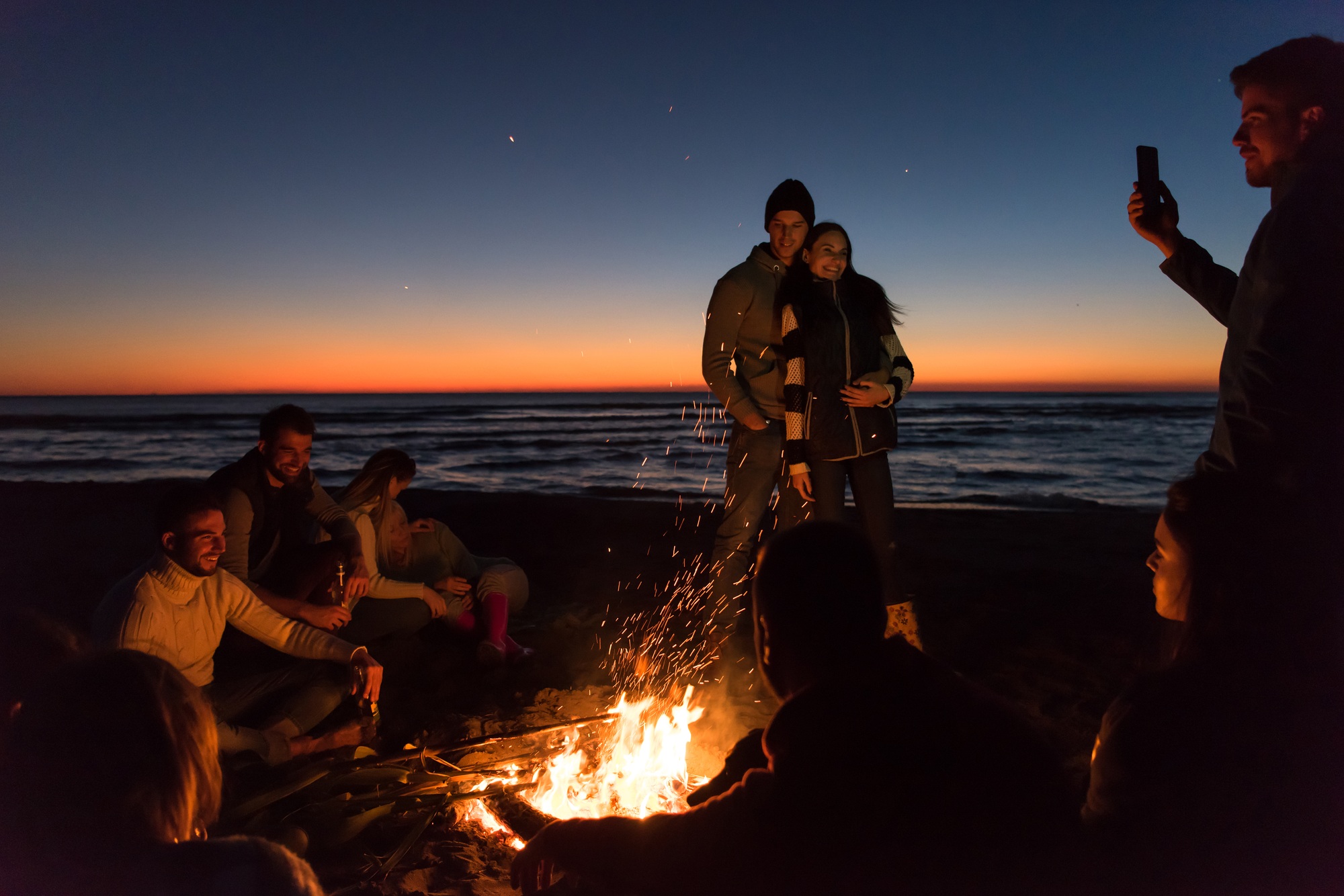 Friends having fun at beach on autumn day